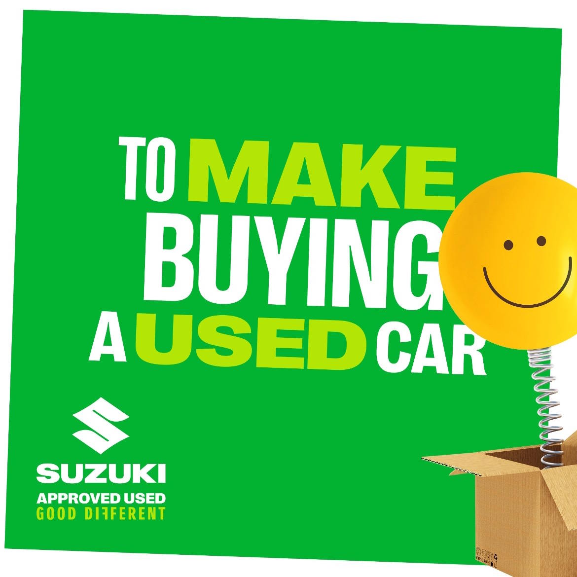 Suzuki Approved Used promotional graphic featuring a cheerful yellow smiley face on a spring emerging from a cardboard box, with bold messaging about buying a used car.