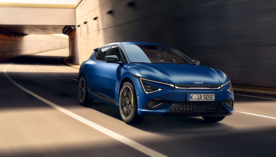 Kia EV6 GT in blue driving in an urban underpass. 