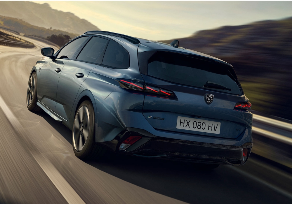 Peugeot 308 SW estate car shown from rear three-quarter angle driving on a winding road.