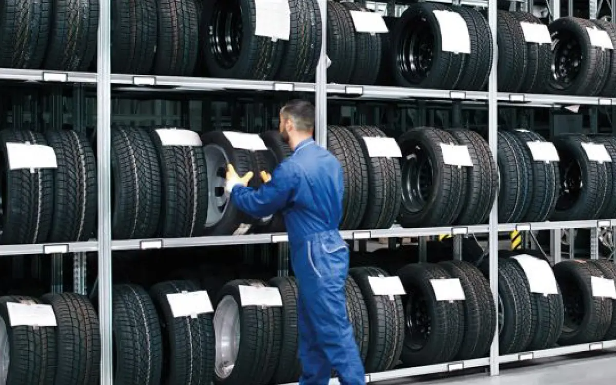 Volkswagen Mechanic Grabbing a Tyre from Tyre Rack
