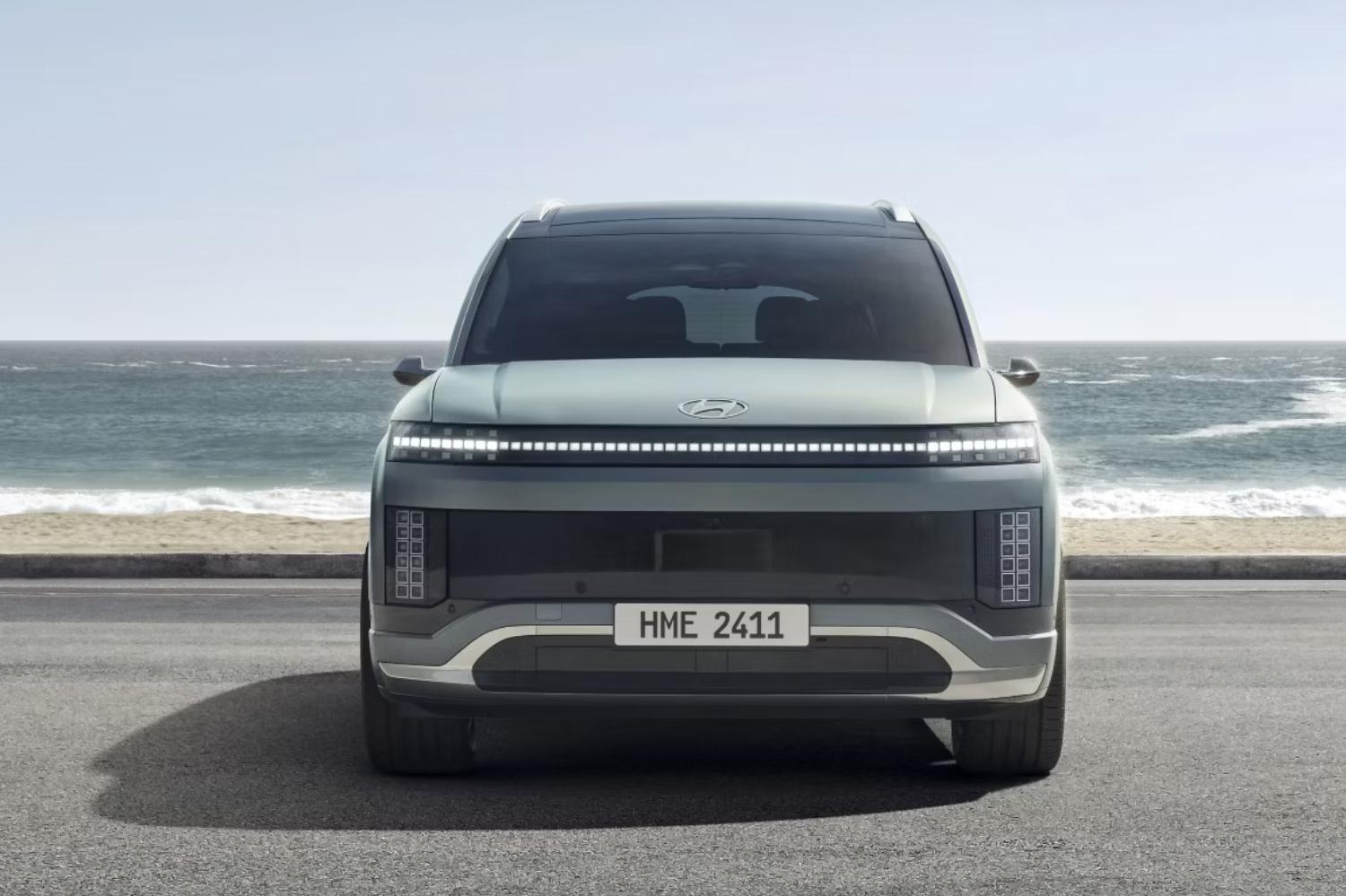 Front exterior of a grey Hyundai IONIQ 9 in front of a beach