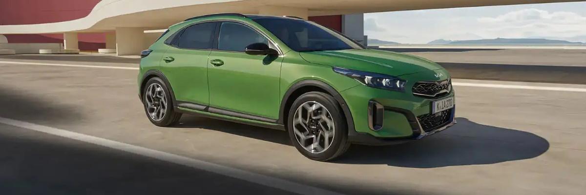 Green Kia XCeed parked in fornt of a concrete bridge painted cream