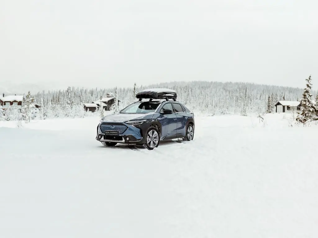 blue subaru touring in the snow