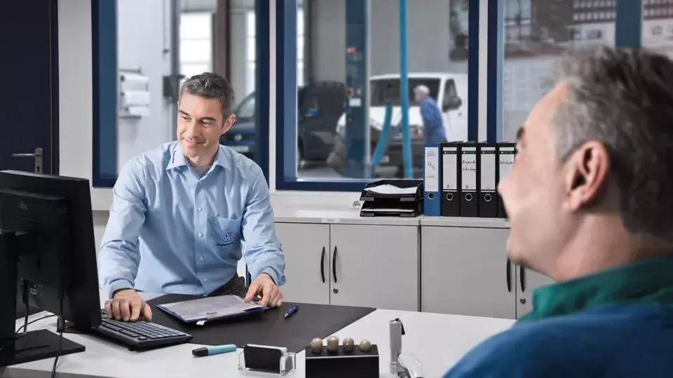 Salesmen with customer at desk