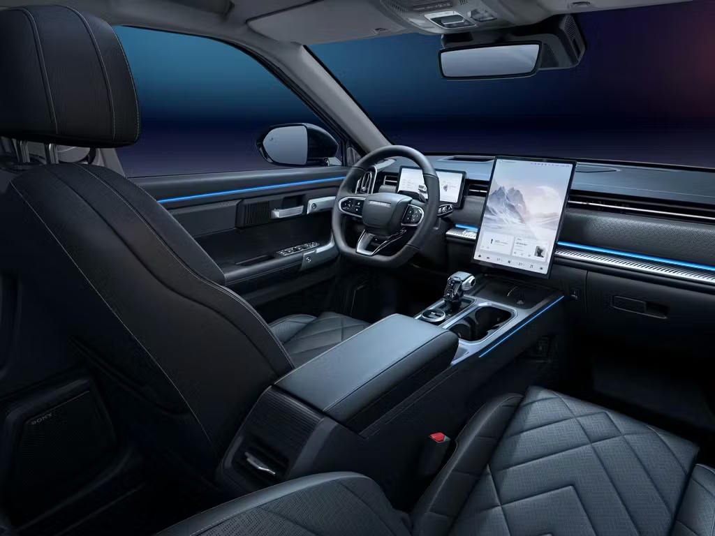 Interior view of the Jaecoo 7 SUV showcasing the premium black leather seats with diamond quilting, large portrait touchscreen, digital instrument cluster and blue ambient lighting accents.