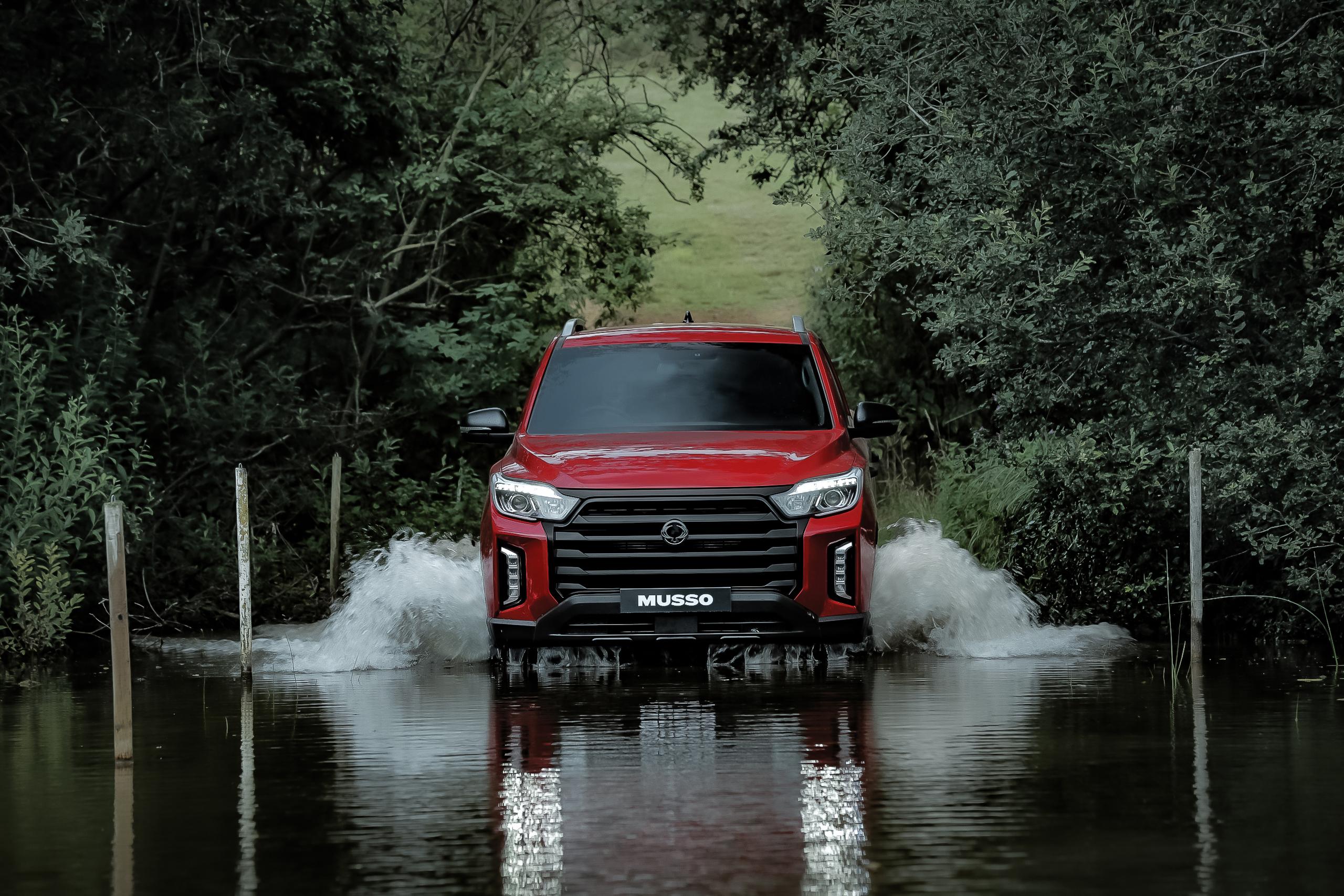 Red SsangYong driving through water