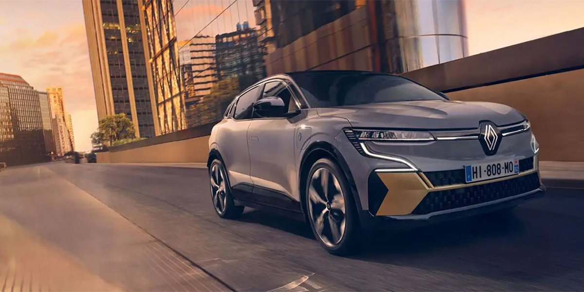 Grey Renault Megane driving along road front facing
