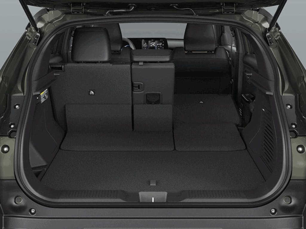Boot space view of the Suzuki e Vitara compact SUV with tailgate open, showcasing the flat load floor, black carpet lining and split-folding rear seats for flexible cargo capacity.