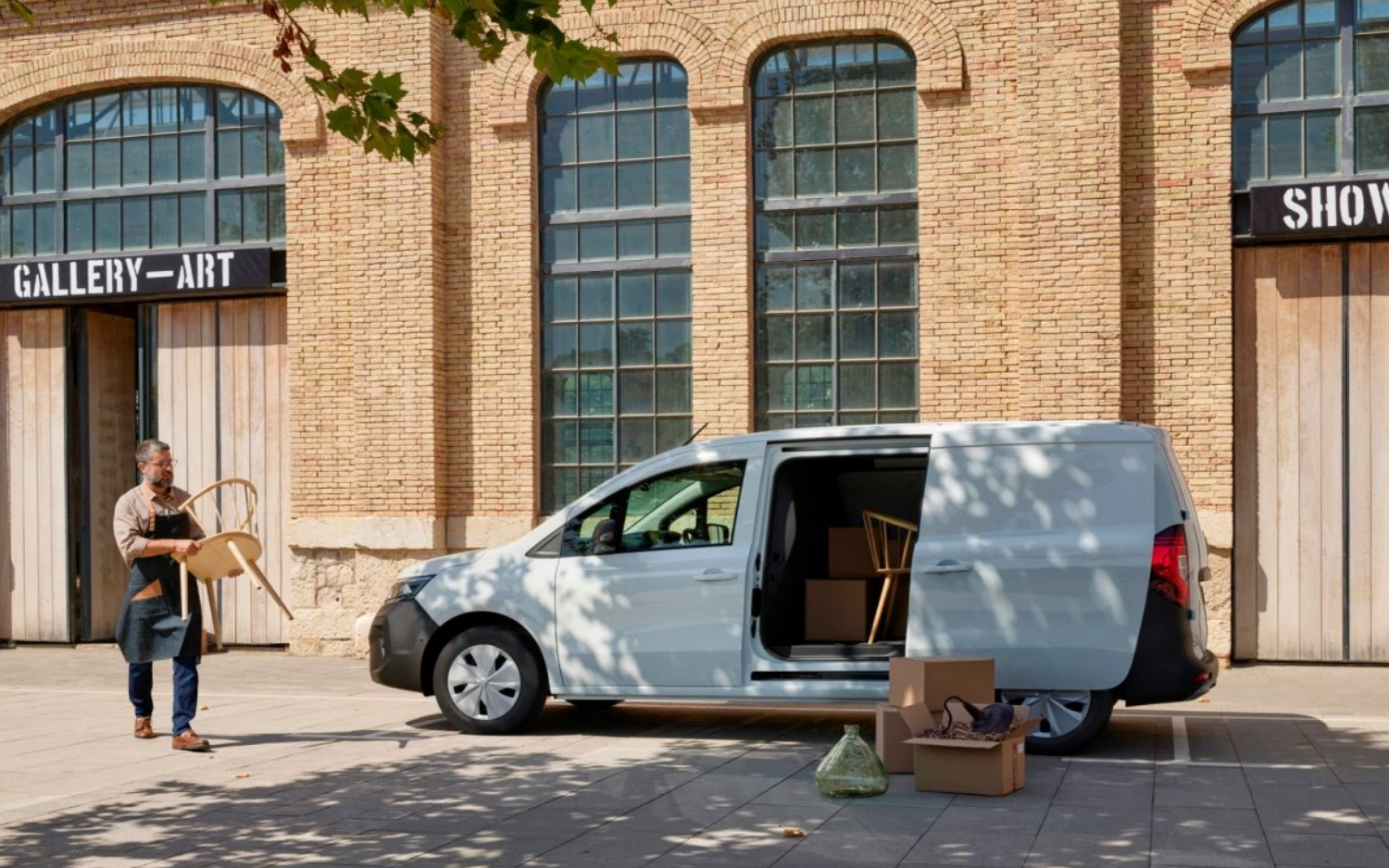 A man loading a Nissan Townstar EV through the side door