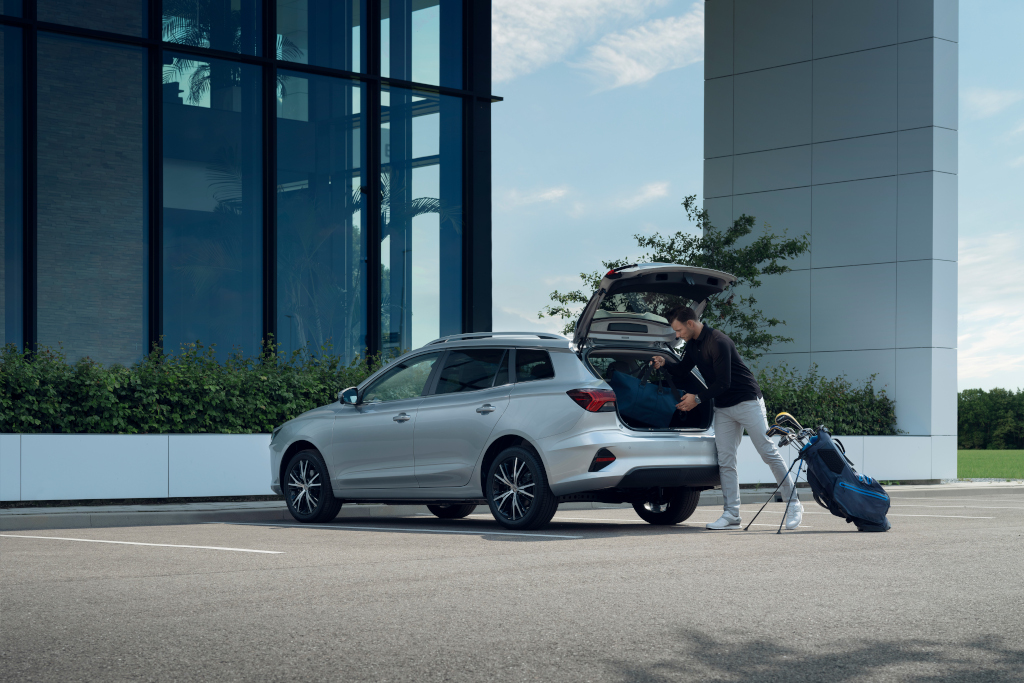 Silver car parked with man loading gold clubs into boot