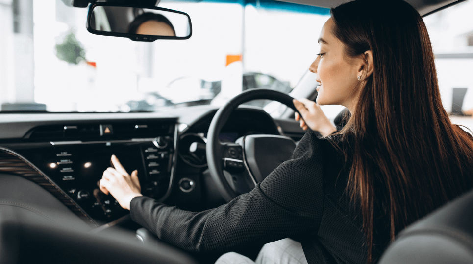 Woman test driving a car and trying out the car safety tech