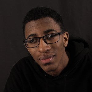 Close-up portrait of a person with glasses looking towards the camera.