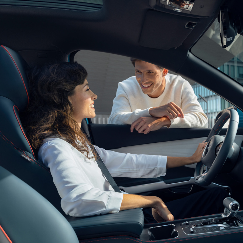 Person Sat In Drivers Seat with Person At Window