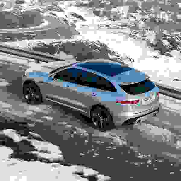 Jaguar F-PACE in grey from behind driving in the snow.