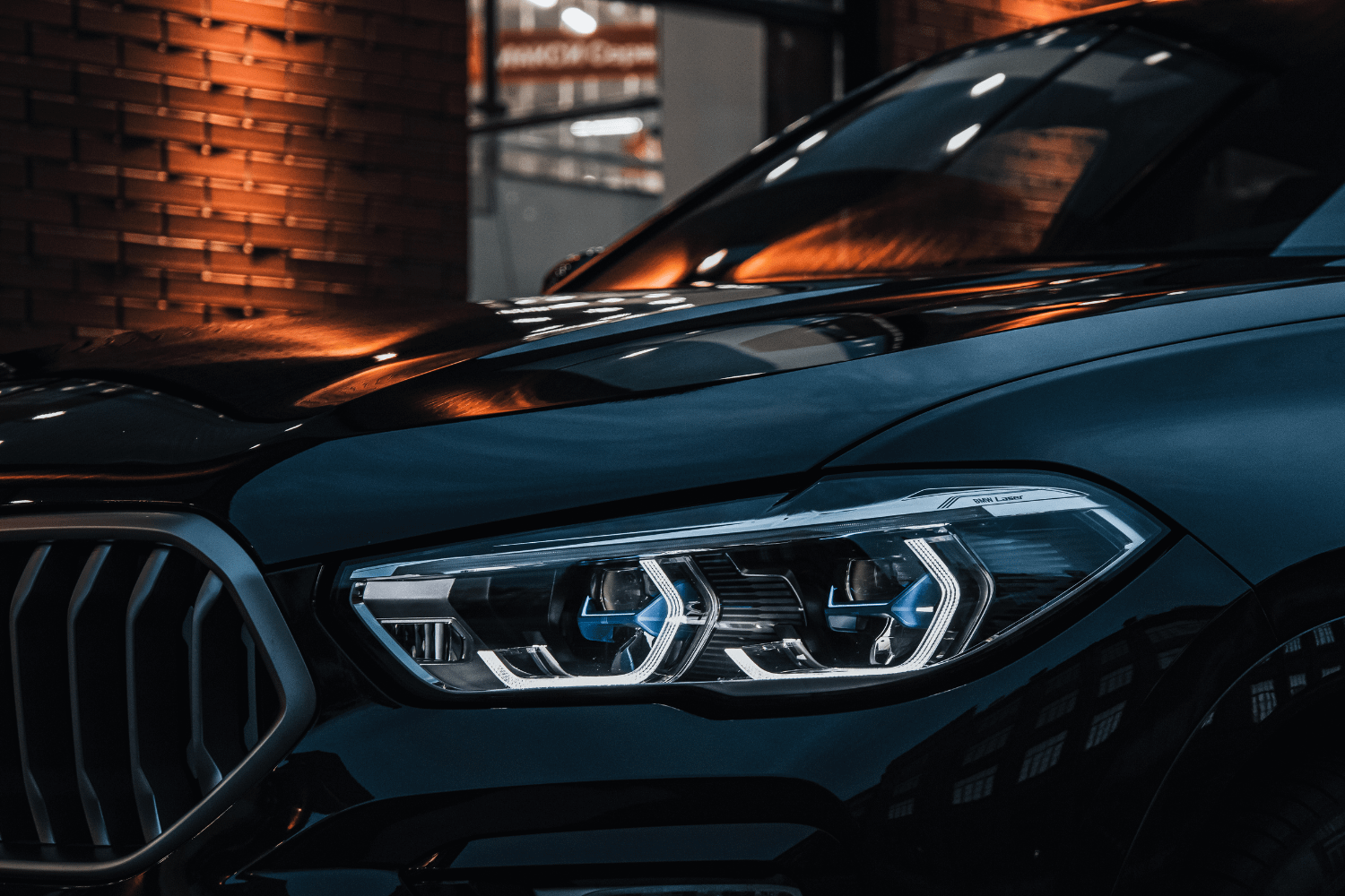 Close-up of BMW headlight and front grille at night.