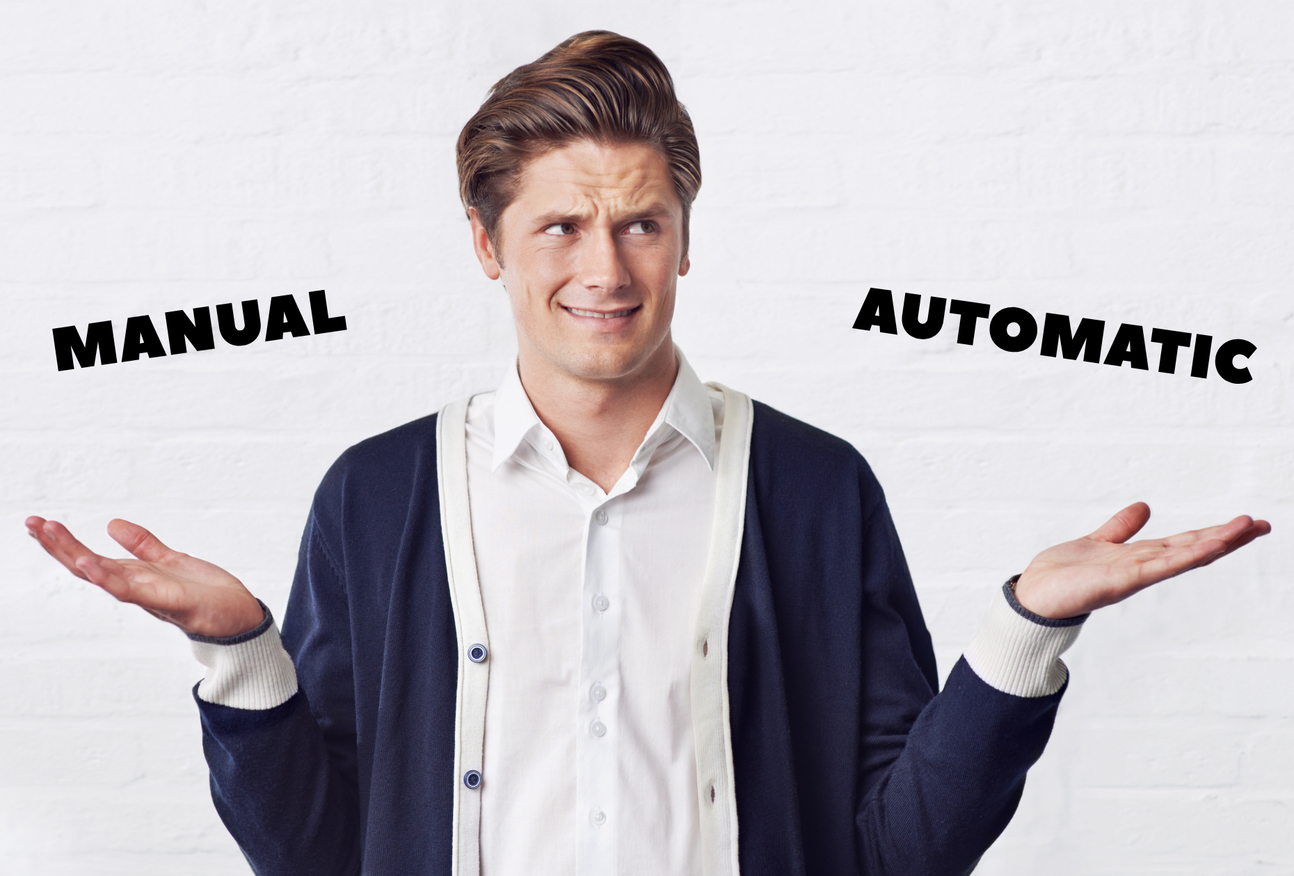 Confused man with his hands up wearing a white shirt with a navy cardigan. This is a white man with brown hair quiffed up and he has his hands out with the text manual and automatic above them