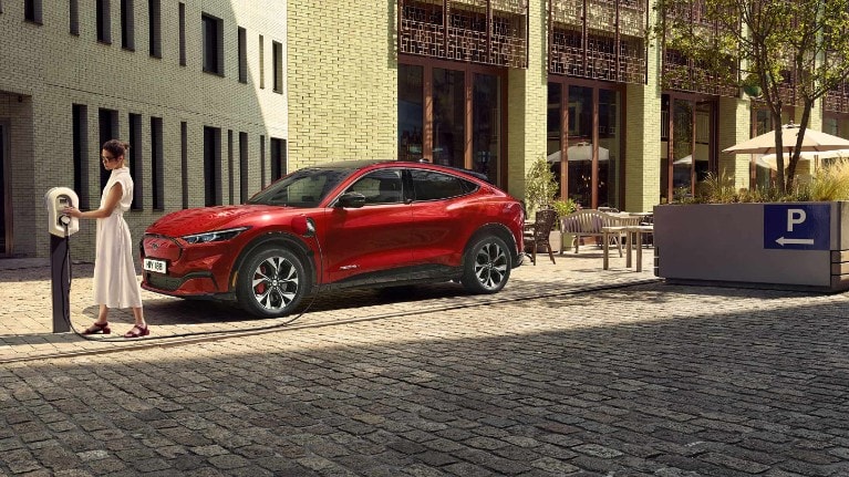 A lady using the FordPass features to find an electric vehicle charging point