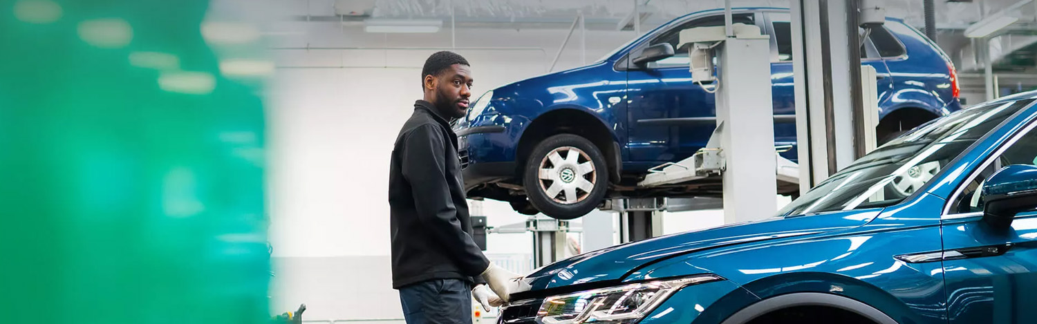 Volkswagen Mechanic Stood By VW Vehicle