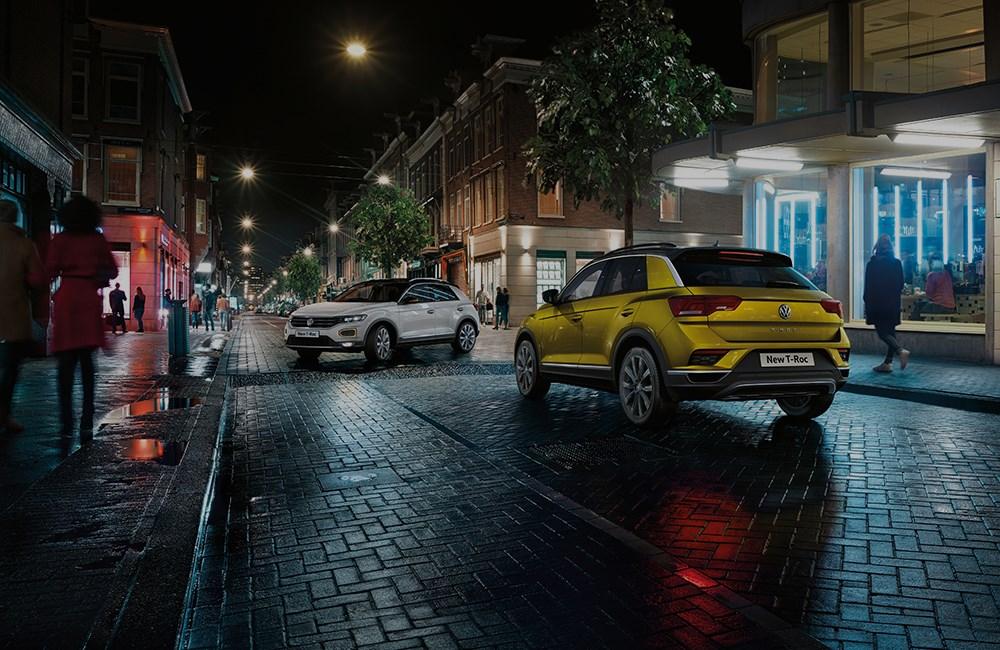 Yellow and white Volkswagen T-Roc in city street at night