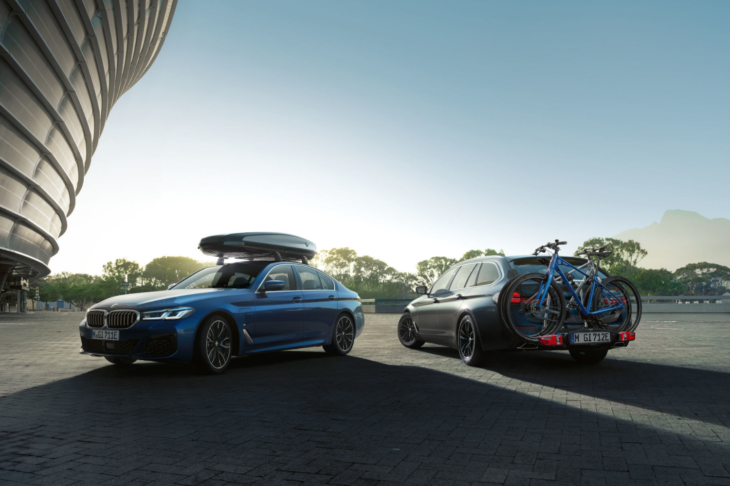 BMW saloon and touring with roof box and bike rack.