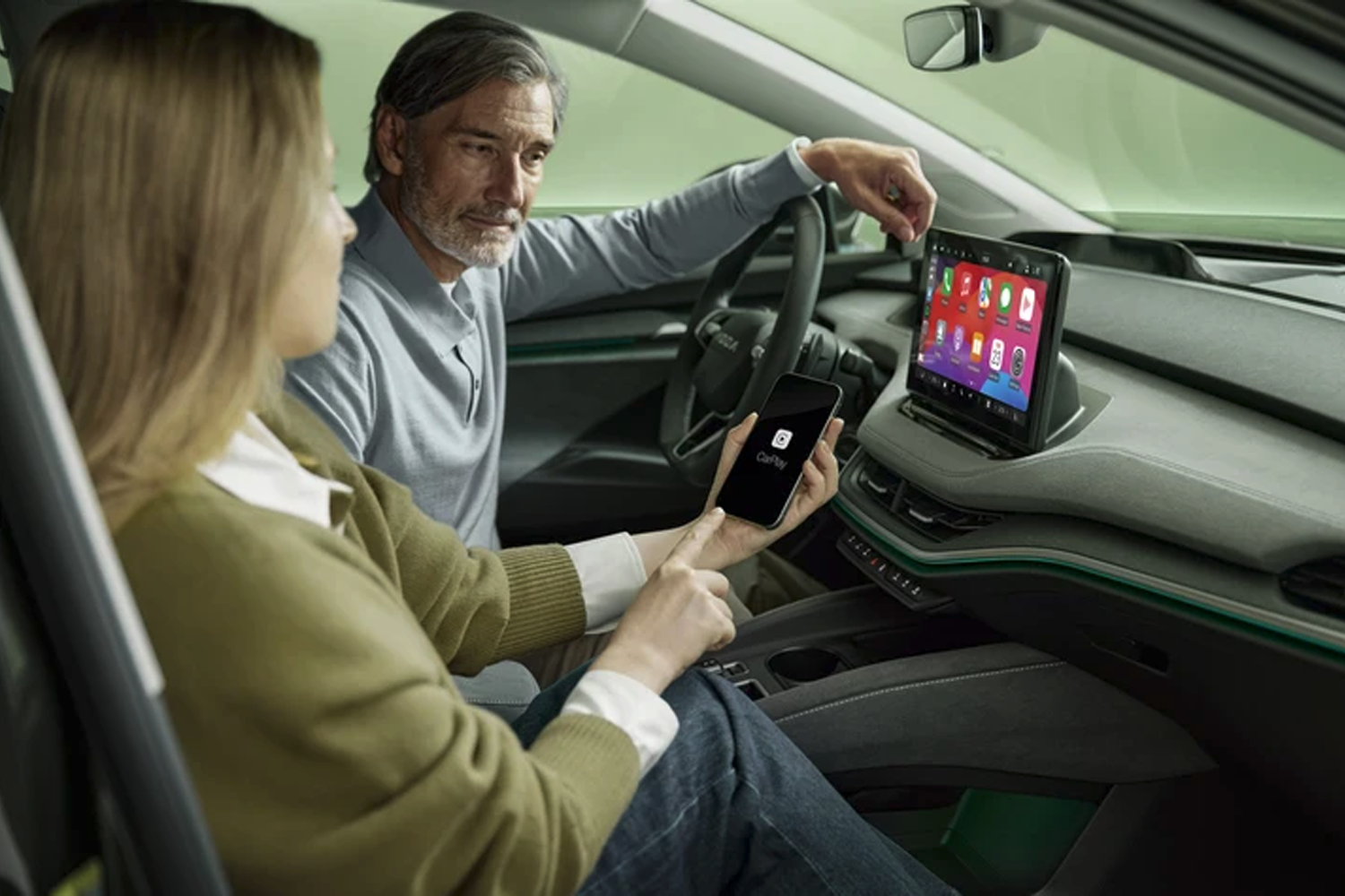 man and woman in front of new skoda enyaq