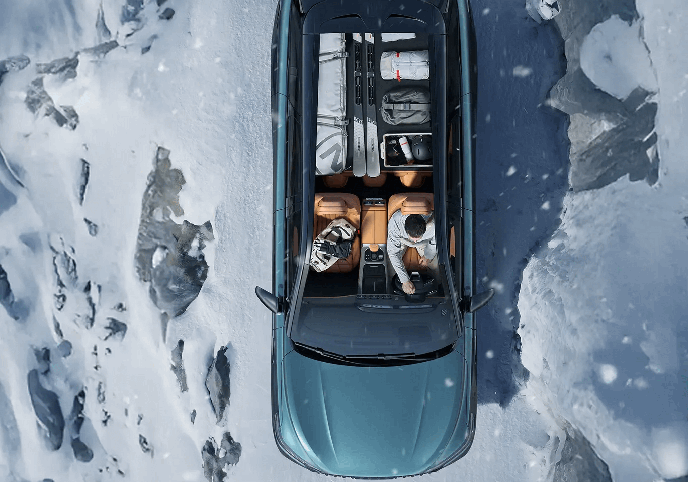 Top-down view of a Jaecoo J8 interior showing passengers and cargo, including skis and luggage, in a snowy environment.