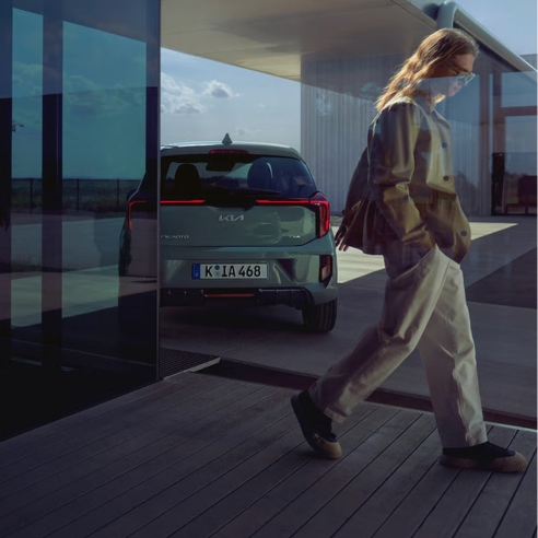 Kia Picanto rear exterior view parked outside a modern house.