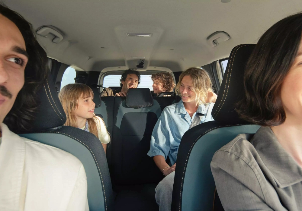 Dacia Jogger interior with a family seated across multiple rows, highlighting spacious cabin and passenger comfort.