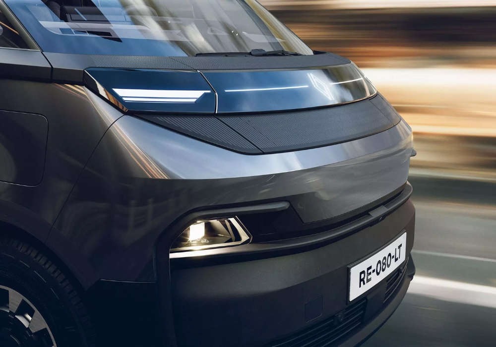 Front exterior close-up of Renault Trafic E-Tech Electric van highlighting sleek grille panel, LED lighting and modern front design.
