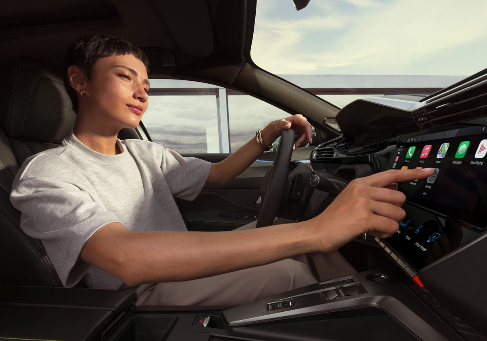 Interior of Peugeot 408 showing a woman in the driver’s seat interacting with the touchscreen infotainment system.
