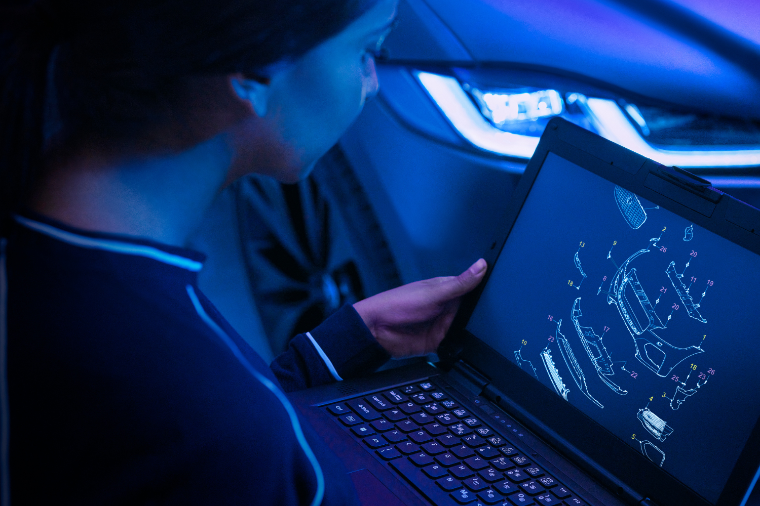 Jaguar technician reviewing vehicle system diagrams on diagnostic laptop.