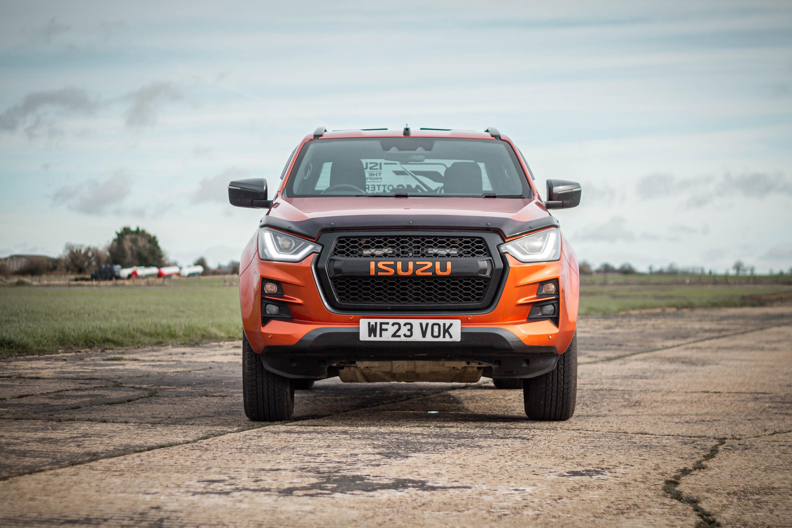 orange isuzu pick up truck parked on airstrip