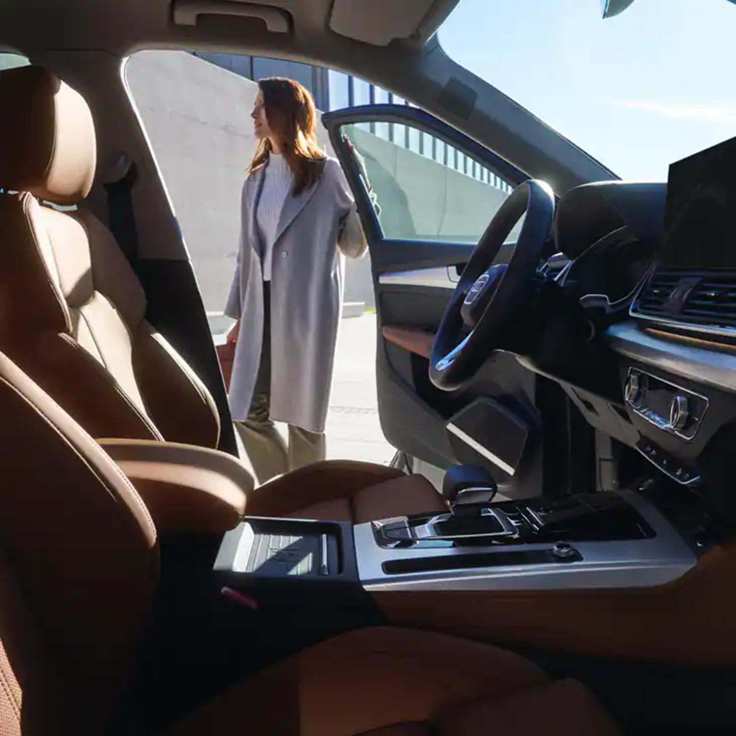 Woman holding the car door open of an Audi