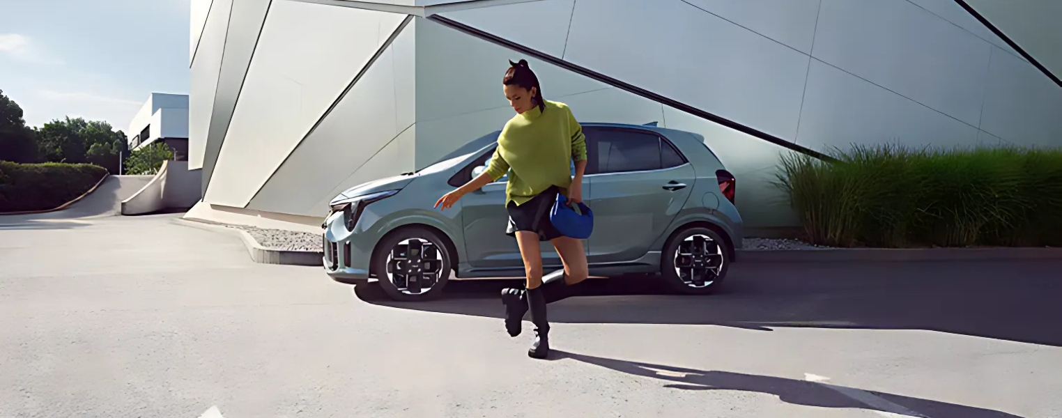 Side profile of a Kia Picanto parked near a contemporary structure.