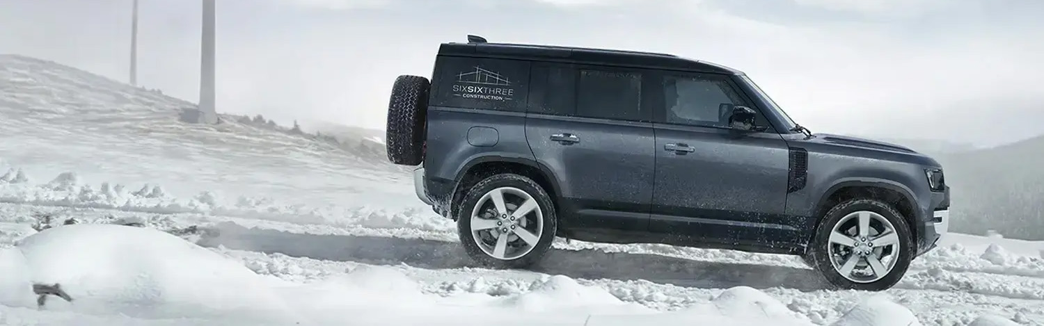 Grey Land Rover Driving In Snow