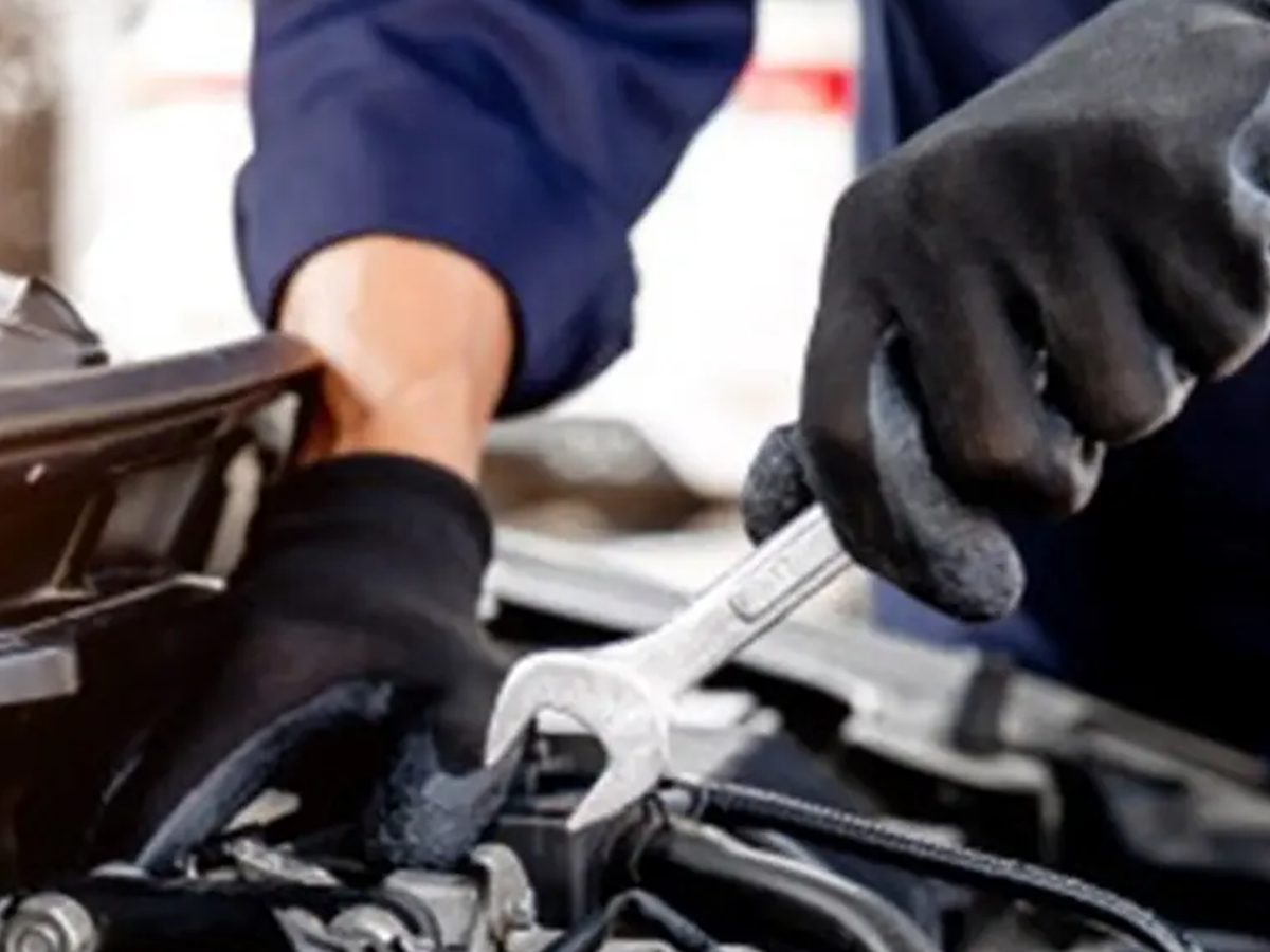 Mechanic using a spanner on a vehicle