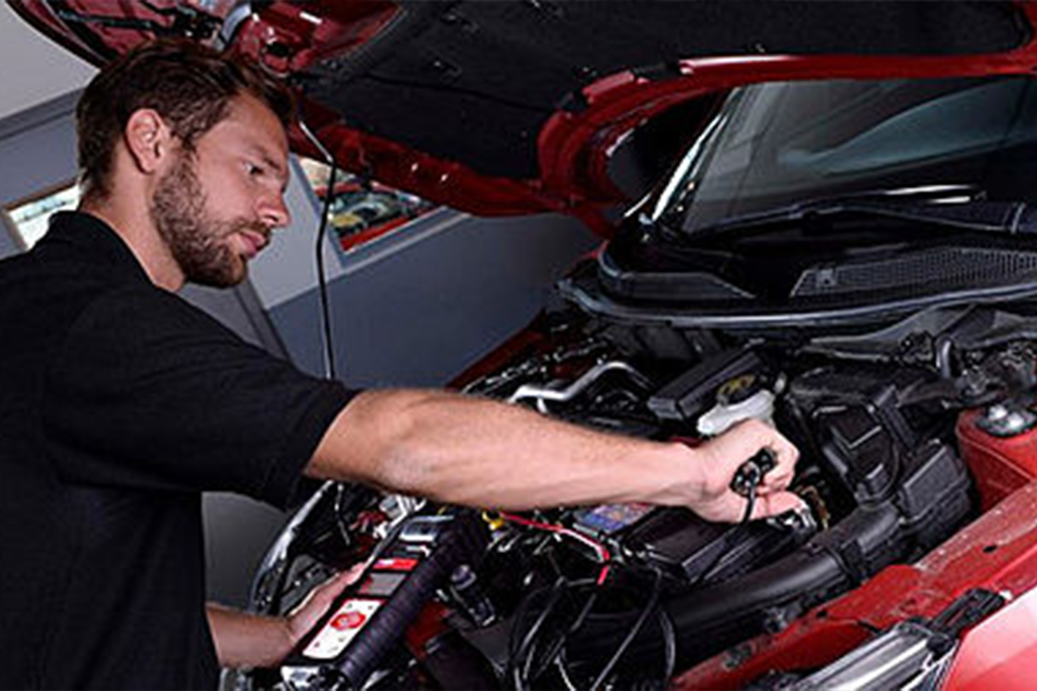 mechanic looking under bonnet of nissan car