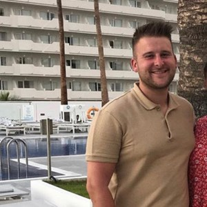 Outdoor portrait of a person in a polo shirt at a hotel poolside location.