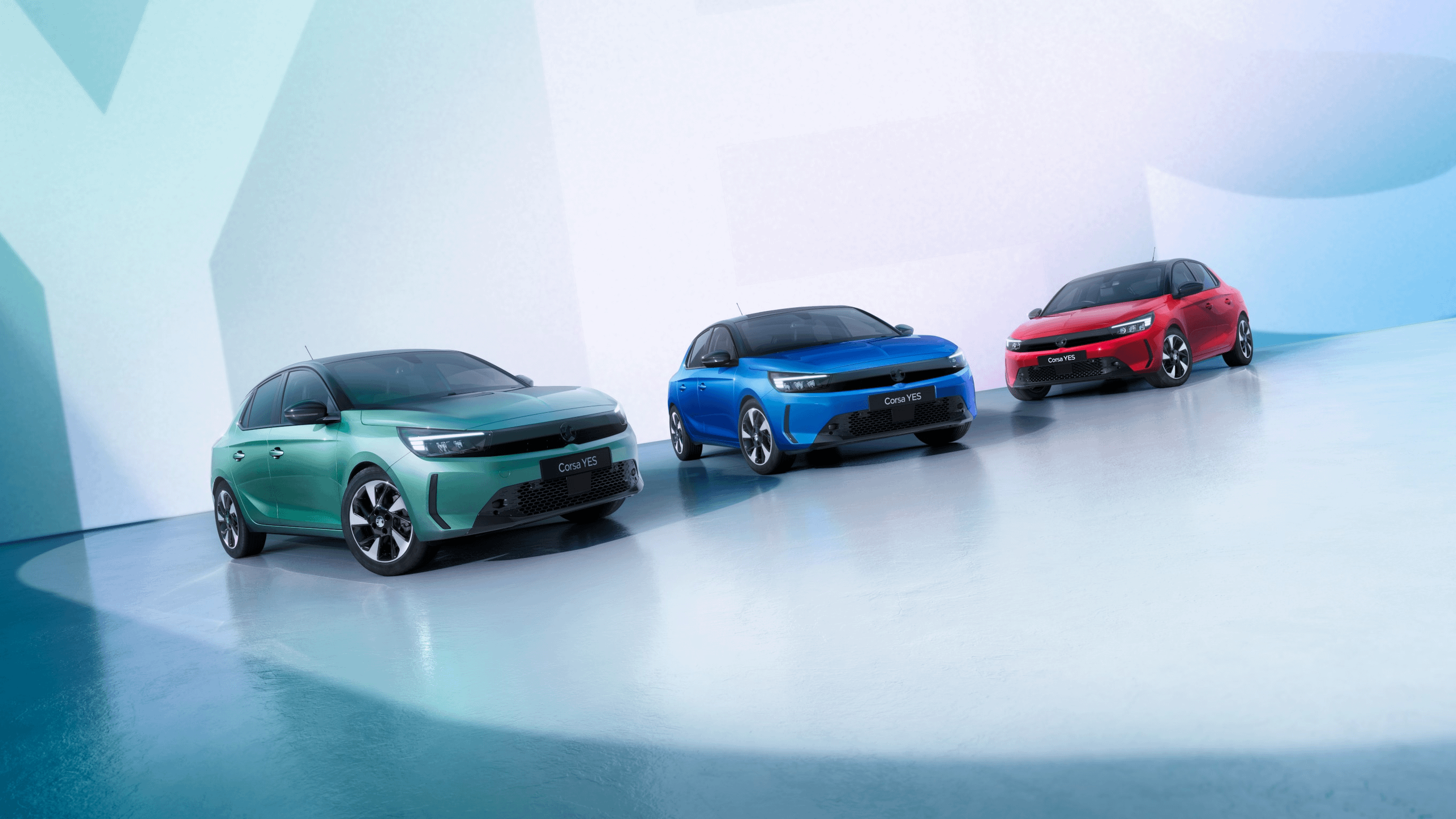 Vauxhall Corsa YES range showcased in green, blue and red finishes in a modern studio.