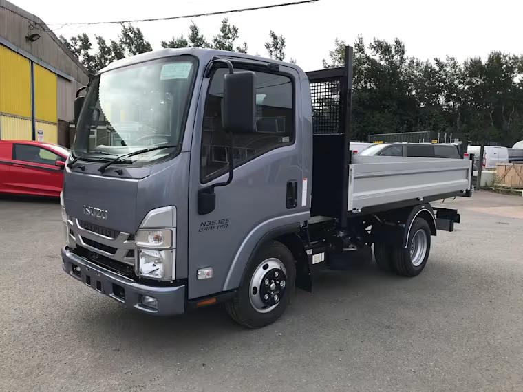 Front three-quarter view of grey Isuzu Grafter dropside truck parked in a commercial yard.