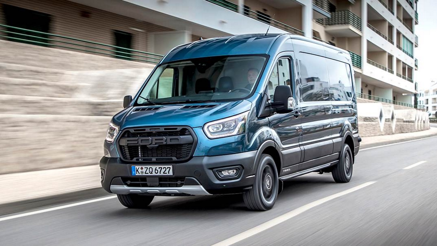 A new Ford Transit van driving on a city street