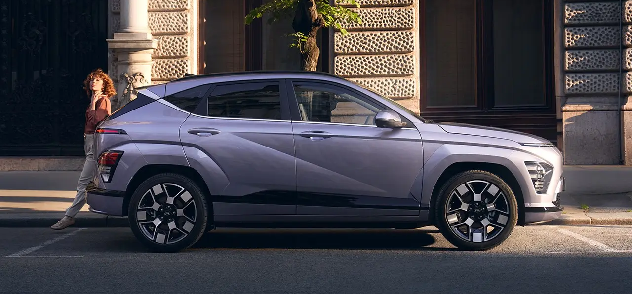 A woman leaning up against a purple Kona