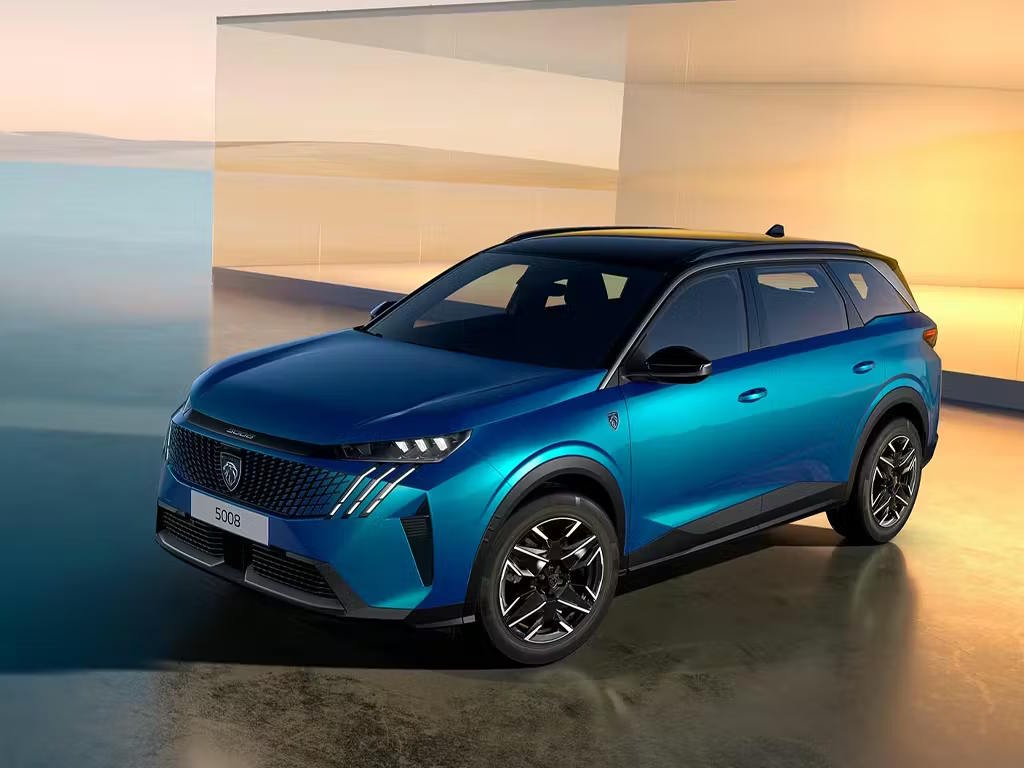 Front three-quarter view of the Peugeot 5008 SUV in striking blue, featuring bold LED daytime running lights, muscular wheel arches and distinctive multi-spoke alloy wheels.