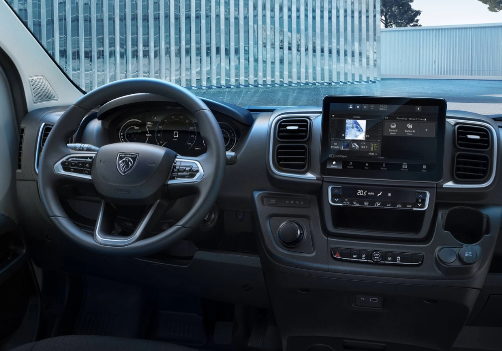 Peugeot e-Boxer dashboard layout with steering wheel, digital display and central touchscreen controls.