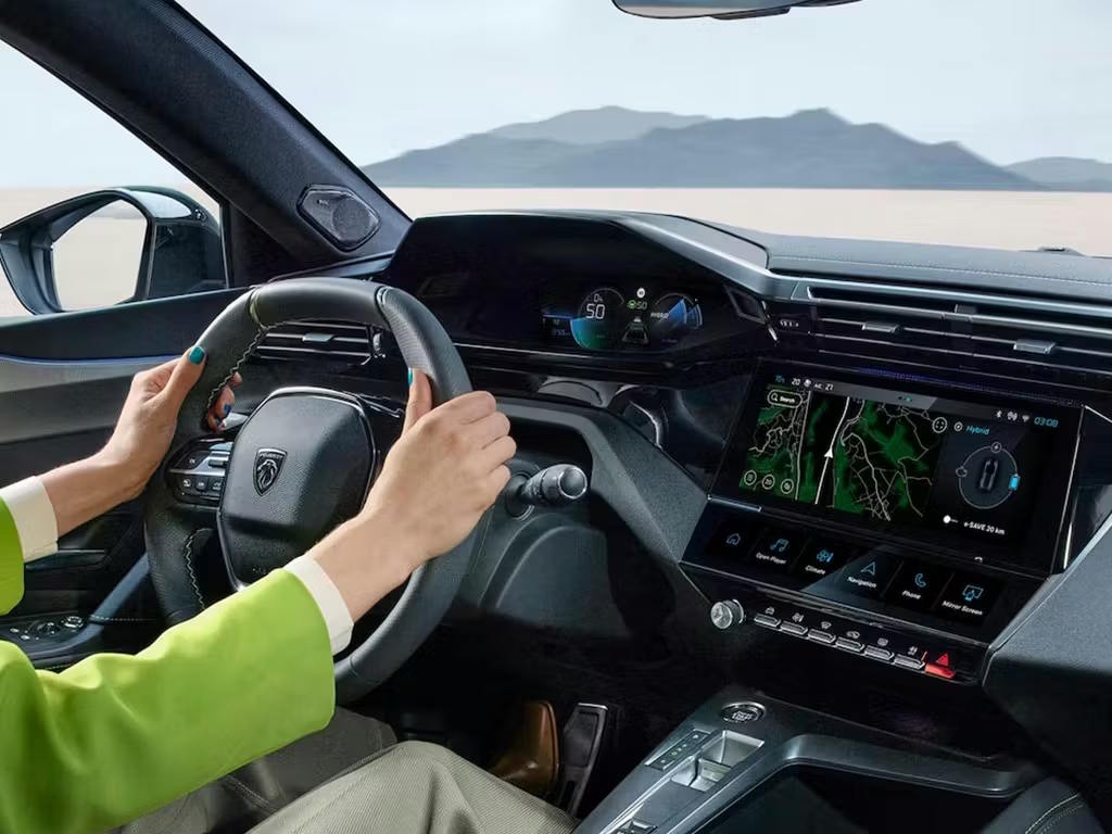 Peugeot 408 i-Cockpit interior with compact steering wheel, digital driver display, touchscreen infotainment system and intuitive driver-focused controls.