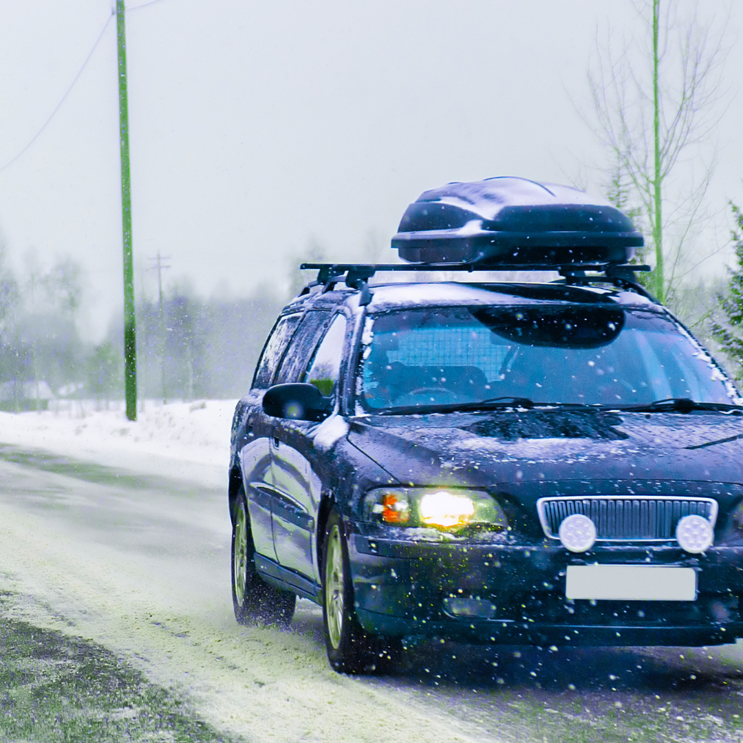 car in winter snow packed up with roof racks