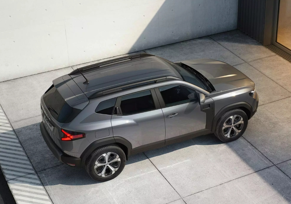Dacia Duster viewed from above in a modern courtyard, highlighting roof rails and overall exterior design.