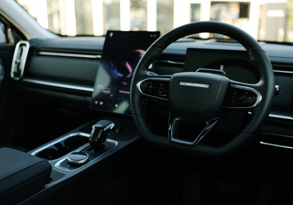 Modern Jaecoo 5 interior showing the steering wheel, digital display, and center console with gear selector.