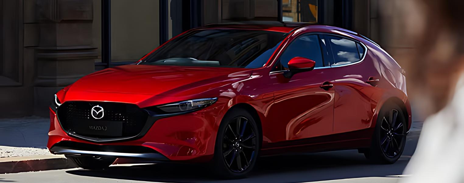 Red Mazda3 Hatchback exterior side view parked in an urban setting.