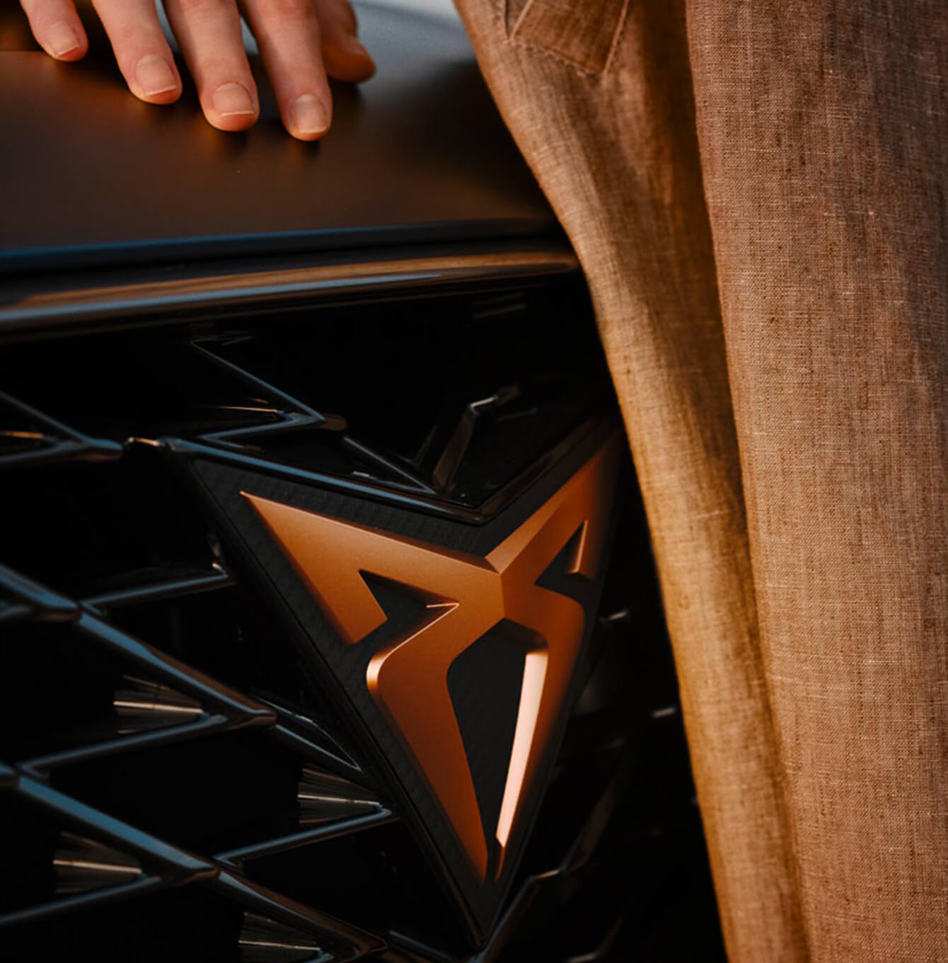 Close-up of a CUPRA badge with copper detailing on the grille.